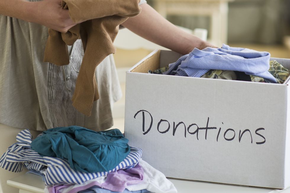 usa, new jersey, jersey city, woman preparing clothing for donation