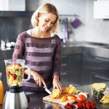 woman chopping fruit for a smoothie