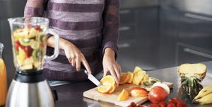 woman chopping fruit for a smoothie