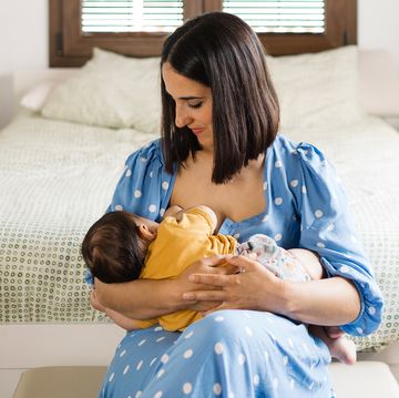 mom breastfeeding infant in bedroom