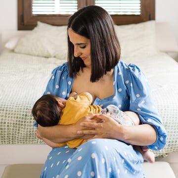 mom breastfeeding infant in bedroom