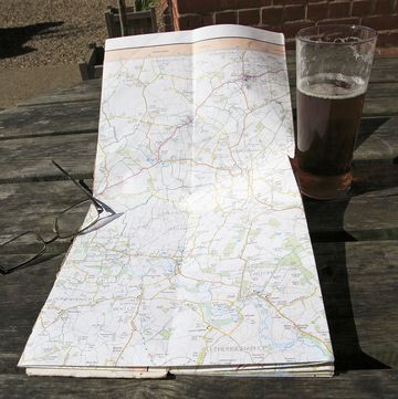 ordnance survey explorer map opened on table with spectacles and pint glass of beer, suffolk, england, uk photo by geography photosuniversal images group via getty images