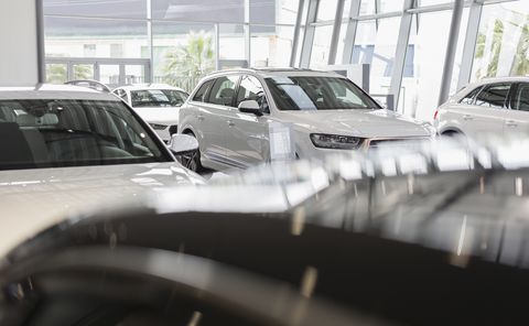 New, white cars in car dealership showroom