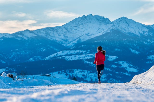 adventure brianna graves running through the snow on a sunny winter day in the methow valley, washington