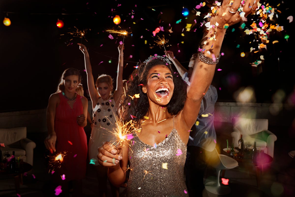 people celebrating on new years eve with sparklers and confetti