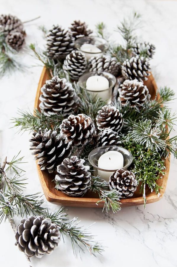 Snow-covered pine cones and branches with eyeballs and candles