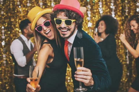 couple having fun on a formal party, with friends on the background