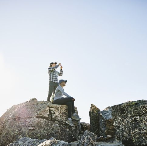 couple taking pictures and enjoying view during sunrise mountain hike
