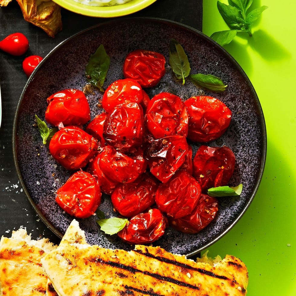 smoky roasted tomatoes on a black plate