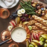 new years eve appetizer platter of cheese fondue breadsticks and sliced fruit