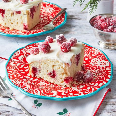 cranberry cake with white frosting and sugared cranberries