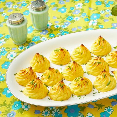 duchess potatoes on white plate with yellow and blue background