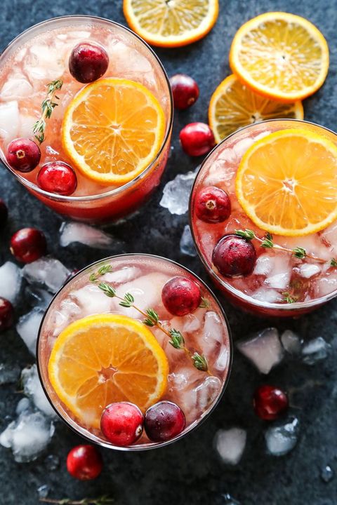 cranberry thyme gin and tonic with orange slices overhead