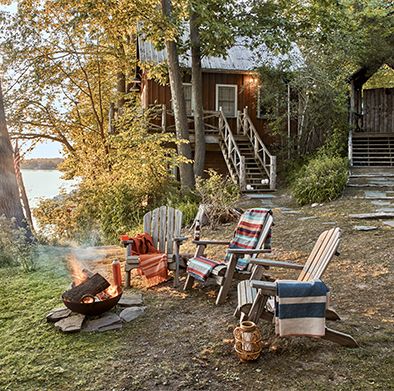 a trio of adirondack chairs set up around a fire pit
