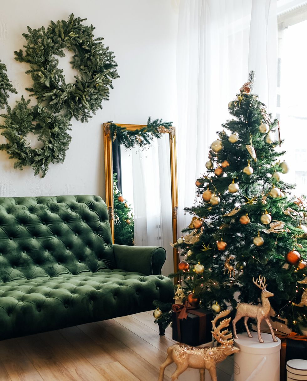 a green couch with a christmas tree and a mirror