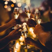 numerous hands holding champagne flutes with champagne celebratory toast silhouettes