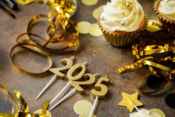 table decorated in gold streamers, stars cupcakes and 2025 candles