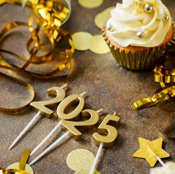 new years wishes - table decorated in gold streamers, stars cupcakes and 2025 candles table decorated in gold streamers, stars cupcakes and 2025 candles