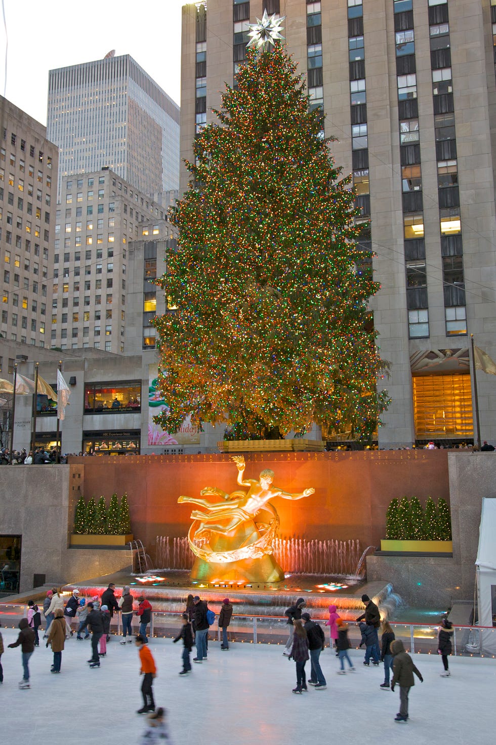 Rockefeller Center's ice skating rink, Christmas tree and 30 Rockefeller Plaza, New York, NY, USA a large christmas tree in a plaza