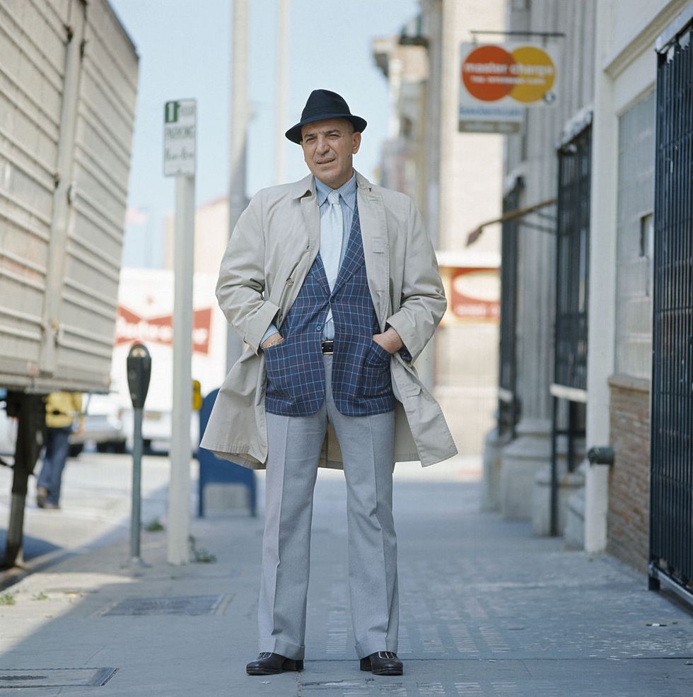 actor telly savalas stands on a city street
