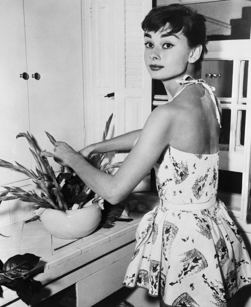 audrey hepburn arranging flowers in kitchen