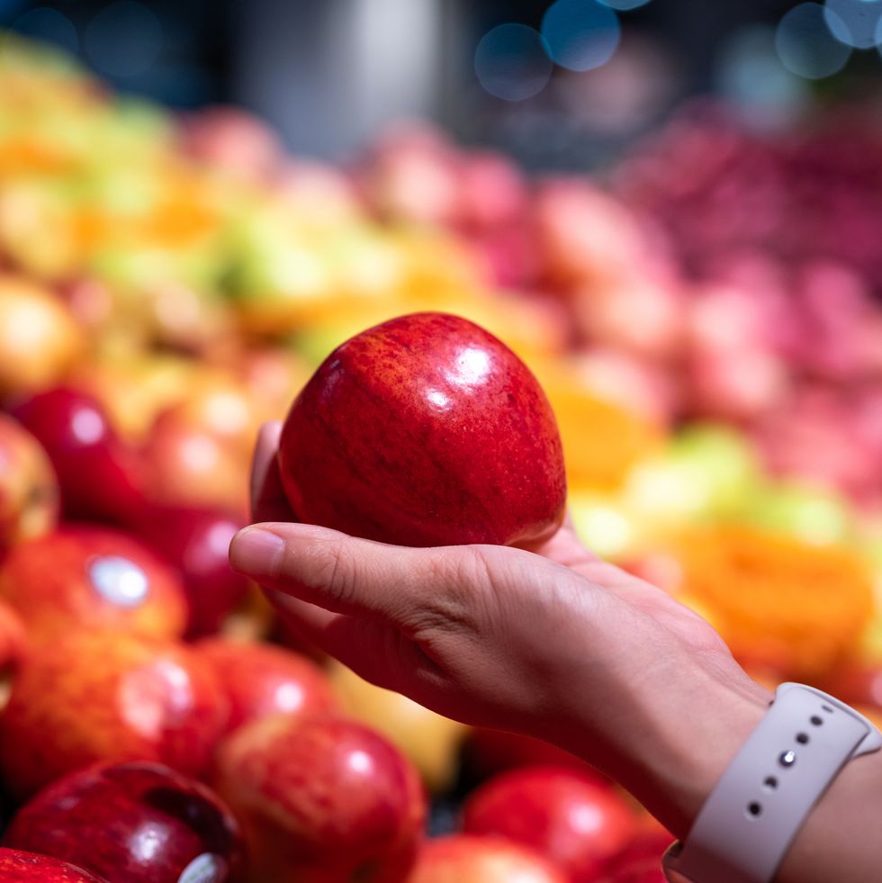 a new zealand red apple is in the woman's hand