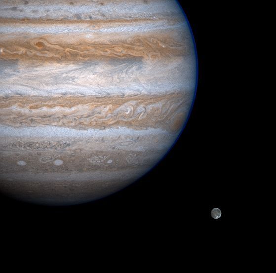 Jupiter werpt een dreigende blik op de maan Ganymedes op dit bewerkte beeld van de NASAruimtesonde Cassini