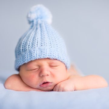 newborn baby boy sleeping peacefully wearing knit hat