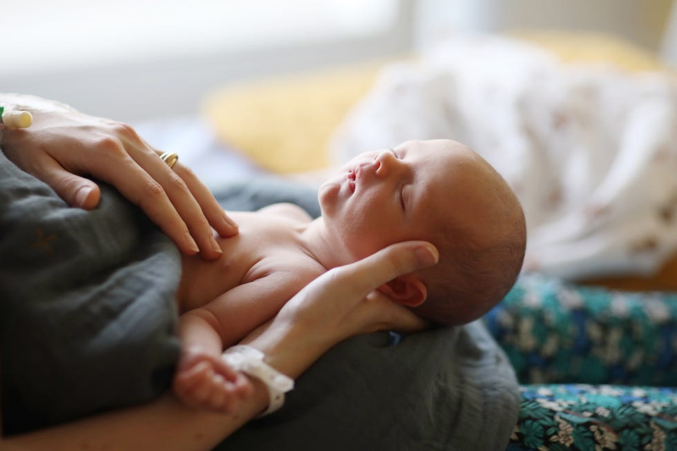bebé recién nacido dormido en los brazos de su madre