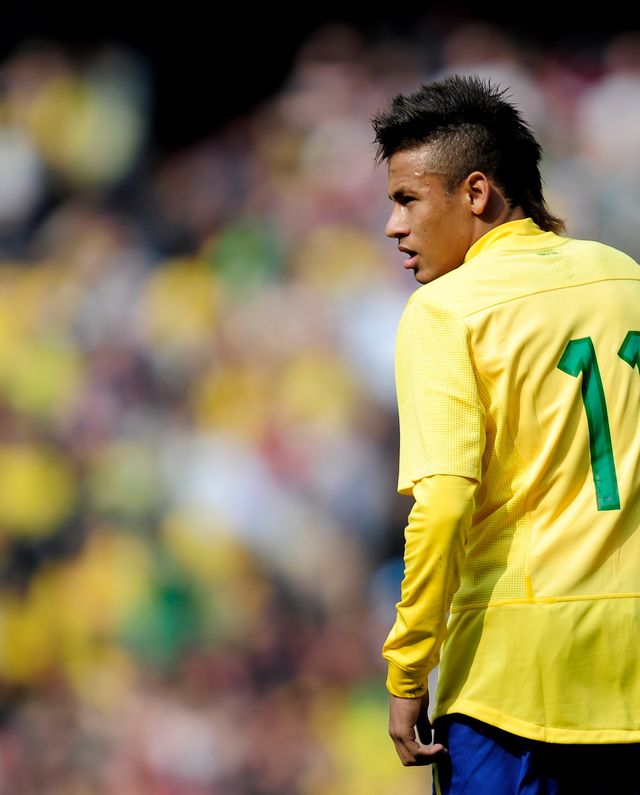 neymar faces away from the camera and looks over his left shoulder, he wears a yellow brazil jersey with green number 11