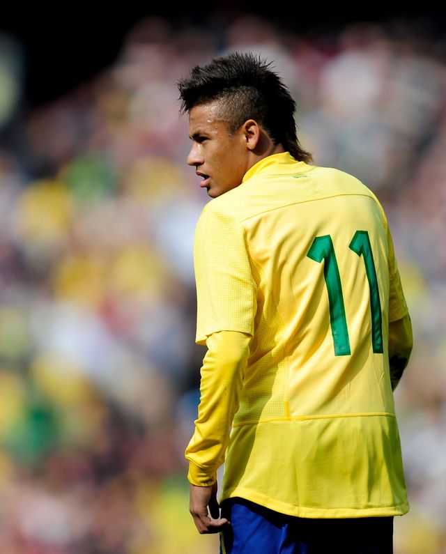neymar faces away from the camera and looks over his left shoulder, he wears a yellow brazil jersey with green number 11