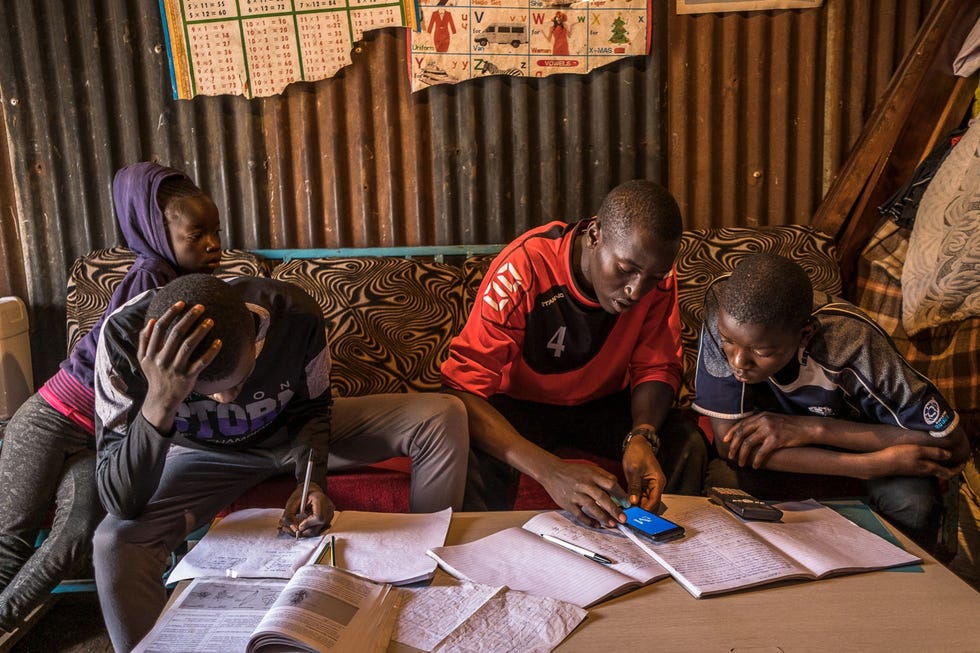 Nairobi, Kenya NAIROBI KENIADe 18jarige Stephen Onyango midden geeft zijn broers Collins en Gavan les terwijl hun zus Genevieve Akinyi toekijkt in hun woning in Kibera Ze gingen niet meer naar school sinds de Keniaanse regering halverwege maart alle scholen sloot om de verspreiding van COVID19 tegen te gaan Stephen vertelde fotograaf Brian Otieno dat zijn leraar hem een app had aangeraden om les te geven aan zijn broers Het is mijn verantwoordelijkheid om ervoor te zorgen dat mijn broertjes thuis studeren na het coronavirus er is en we weten niet hoelang dit duurt zei hij Kenia heropende de scholenin januari 2021 ondanks het feit dat de pandemie nog niet over was