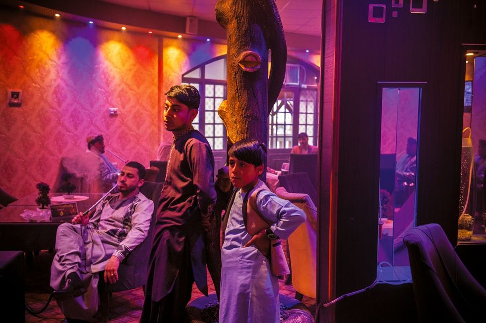 In Cafe Delight in een buitenwijk van Kandahar vermaken zakenlieden ambtenaren en jonge jongens zich door naar sport en videoclips te kijken Hoewel ook vrouwen welkom zijn in deze zaak laten zij zich hier zelden zien Onder de Taliban waren muziek en televisie verboden en mochten vrouwen alleen buitenshuis komen onder begeleiding van een man