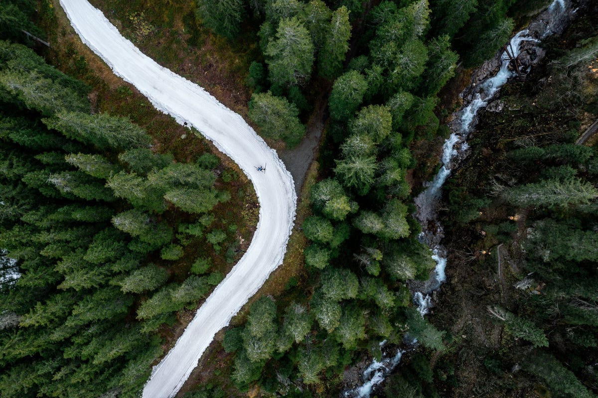 Bij het Zwitserse Davos glijdt een langlaufer eind oktober over een loipe van kunstsneeuw die in de winter ervr is geproduceerd De sneeuw was s zomers opgeslagen in een zes meter hoge berg onder een laag zaagsel van veertig centimeter dik en is aan het begin van het nieuwe seizoen op de loipe gestort