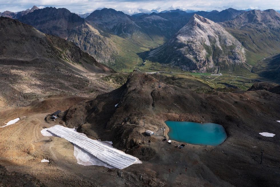 Bij het Zwitserse skioord Diavolezza is een perceel sneeuw afgedekt met dekens om te voorkomen dat het in de zomer smelt De sneeuwval in de Alpen is z onberekenbaar geworden dat de skisector nu vertrouwt op kunstsneeuw die in depots wordt opgeslagen