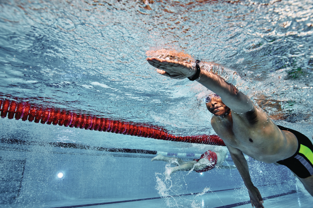 two swimmers competing in a pool with a red lane divider