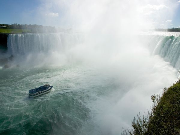 De Maid of the Mist neemt bezoekers mee op een tocht dwars door stuifwater aan de voet van de Horseshoe Falls aan de Canadese kant van de Niagarawatervallen
