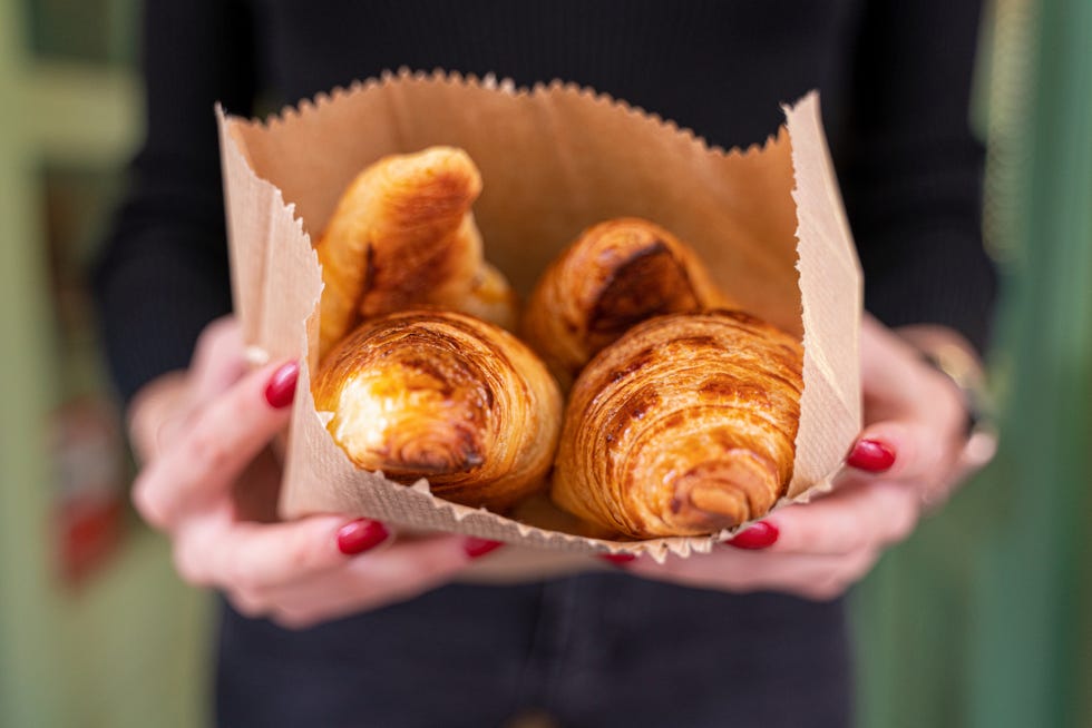 nice little yummy croissants in hands of girl stock photo
