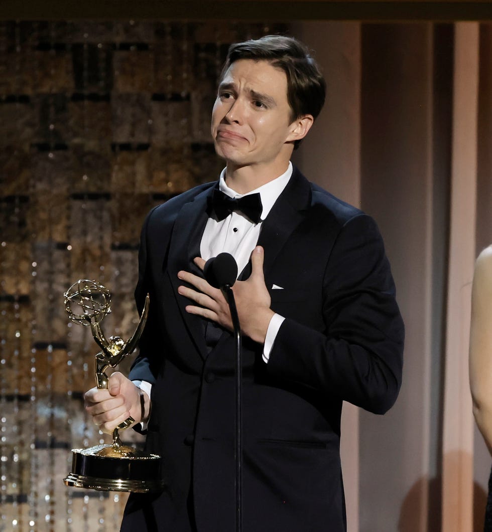 Nicholas Alexander Chávez holds a hand to his chest, holding back tears as he holds a trophy