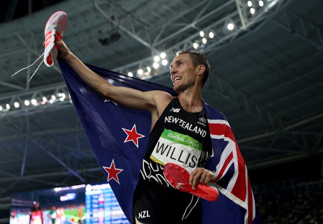 el atleta neozelandés nick willis celebra con la bandera de su país y las zapatillas en la mano celebra el bronce de los 1500 metros en los juegos olímpicos de río 2016