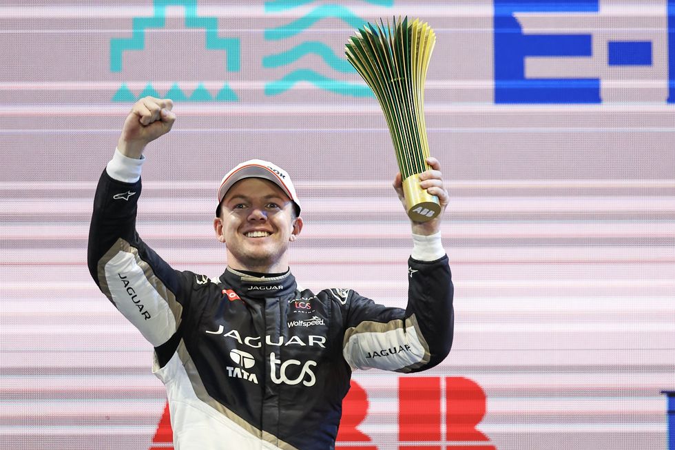 formula e driver nick cassidy smiles and holds his winner's trophy