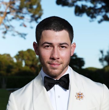 nick jonas smiles wearing white suit