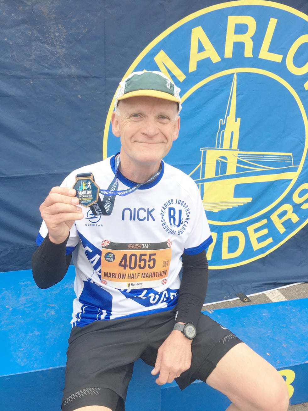 runner is seated and wearing a medal after a marathon