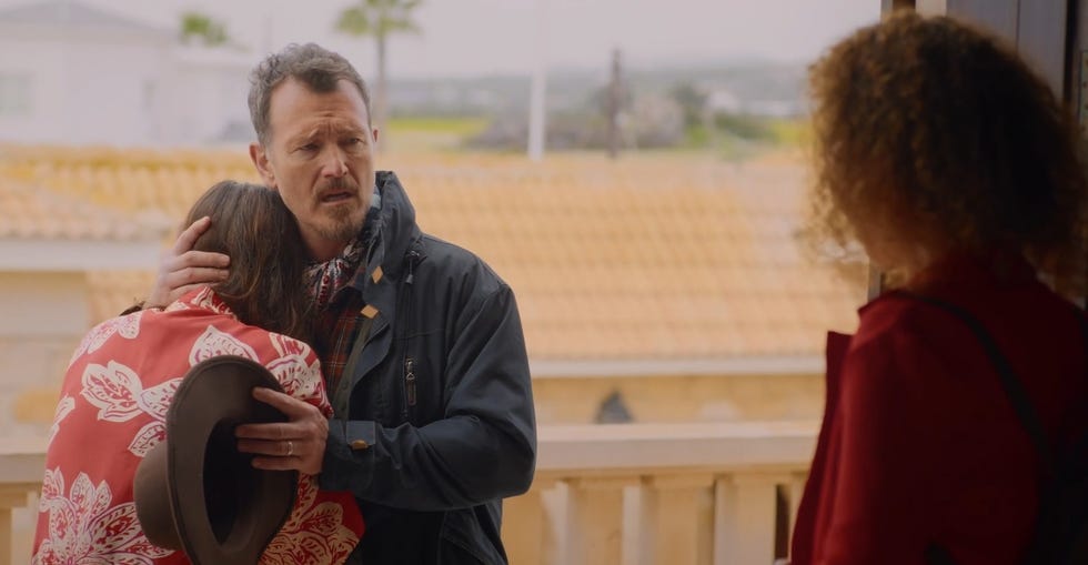 a comforting scene of embrace between two individuals with a woman observing