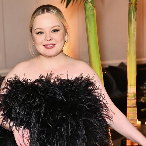 nicola coughlan wearing a black feathered dress and smiling in a photo