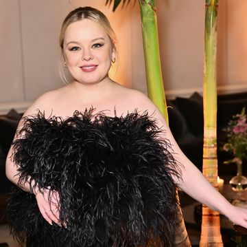 nicola coughlan wearing a black feathered dress and smiling in a photo