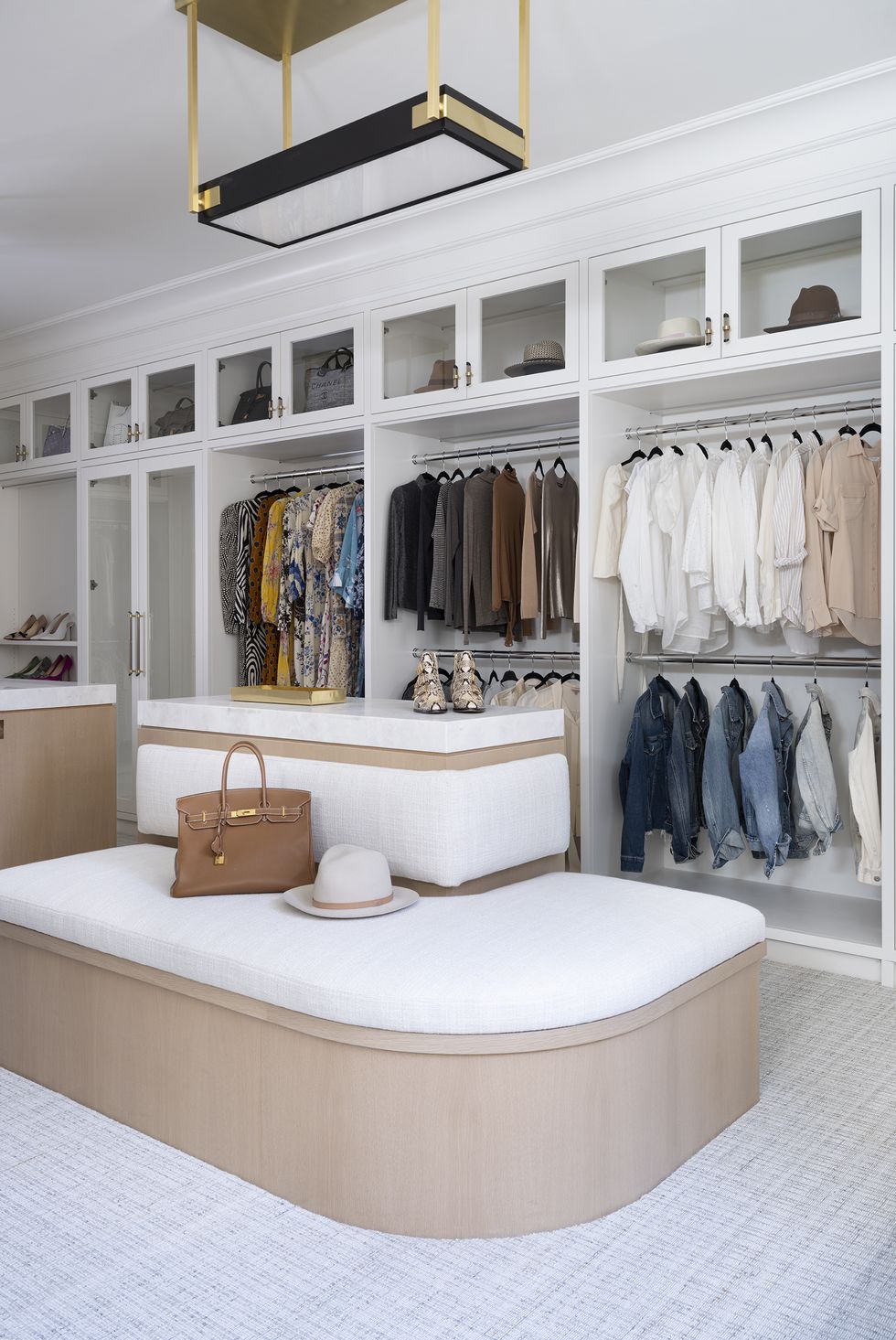 walk in closet with large white seating area