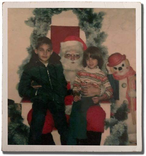 author and brother sitting on santas lap as young children in the 1980s