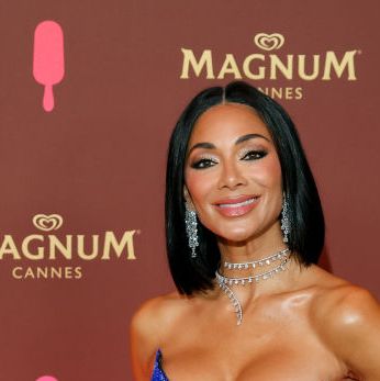 nicole scherzinger poses with her hair down in a strapless blue dress on a magnum cannes branded red carpet