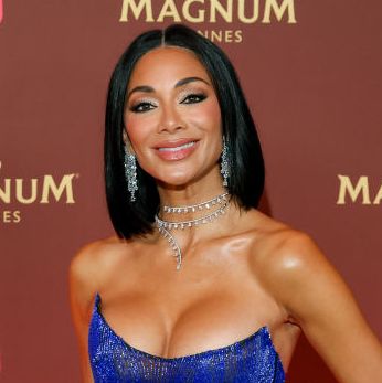 nicole scherzinger poses with her hair down in a strapless blue dress on a magnum cannes branded red carpet